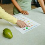 Two adults discussing food options with a chart, highlighting healthy nutrition indoors.